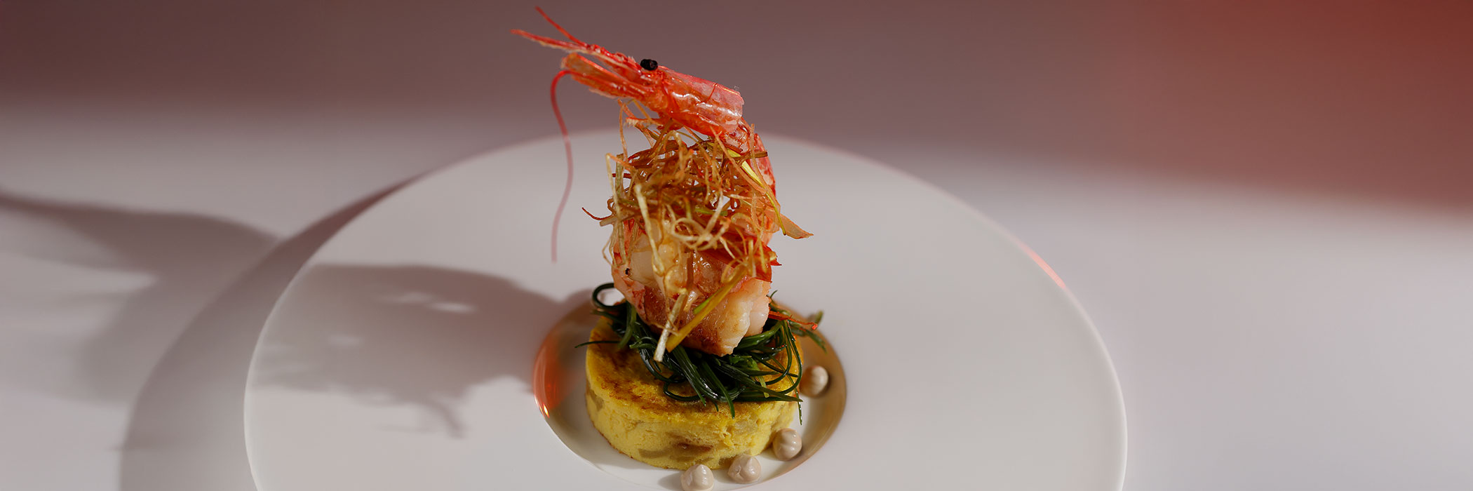 MAIA - ricetta per realizzare dei Gamberoni lardellati con agretti saltati su tortilla di patate e porro fritto